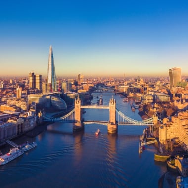 Panoramablick auf die Londoner Skyline mit der Themse, die durch die Stadt fließt, während der Sonnenuntergang.