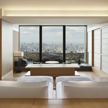 Luxurious hotel room with a panoramic window view of the city skyline in Tokyo, Japan.