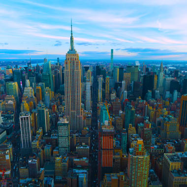 Luftaufnahme der New Yorker Skyline mit dem Empire State Building bei Sonnenuntergang.