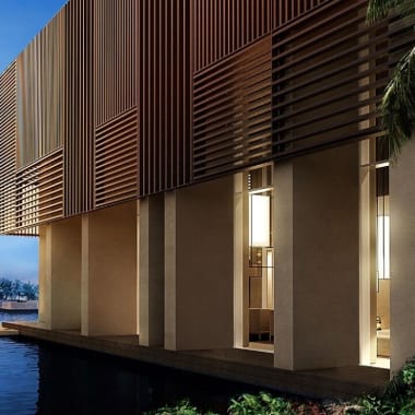  modernes Gebäude mit hohen Säulen und Holzlamellen, reflektiert in einer Wasserfläche, mit üppigem Grün und klarem blauen Himmel.