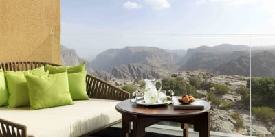 Ein Balkon mit einer gepolsterten Sitzgelegenheit und Blick auf felsige Canyons im Außenbereich.