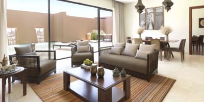 Geräumiges Wohnzimmer mit modernem Mobiliar, große Glasschiebetüren zum privaten Garten mit Pool und eleganter Dekoration.