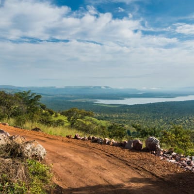 Sandige Strasse mit Blick auf einen See im Akagera Nationalpark