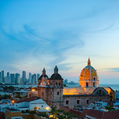 Sunset over Cartagena de Indias with historic buildings and city skyline in the background.
