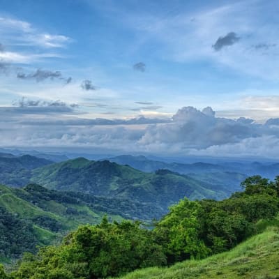 Üppig grüne Berge unter einem teils bewölkten Himmel in Costa Rica.