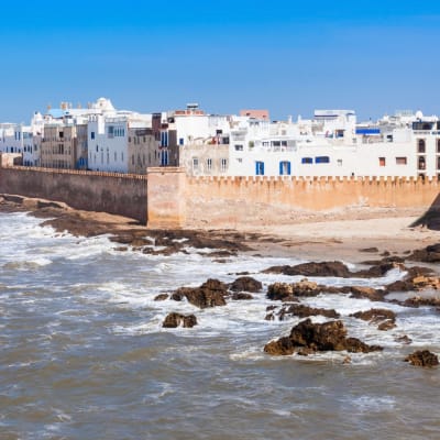 Blick auf die Küstenstadt Essaouira in Marokko mit weißen Gebäuden und einer Festungsmauer am Atlantischen Ozean.
