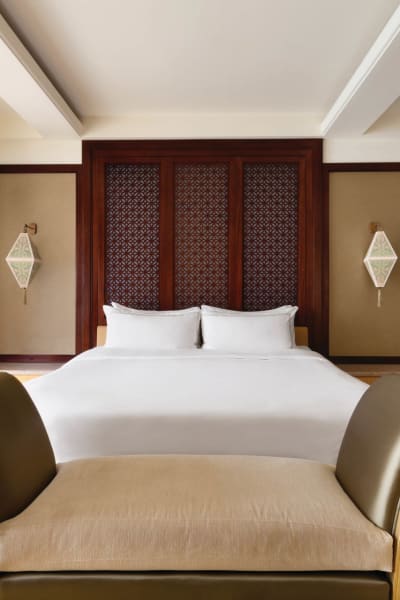 Luxuriöses Schlafzimmer mit großem Bett und eleganter Einrichtung in einer modernen Hotelsuite.