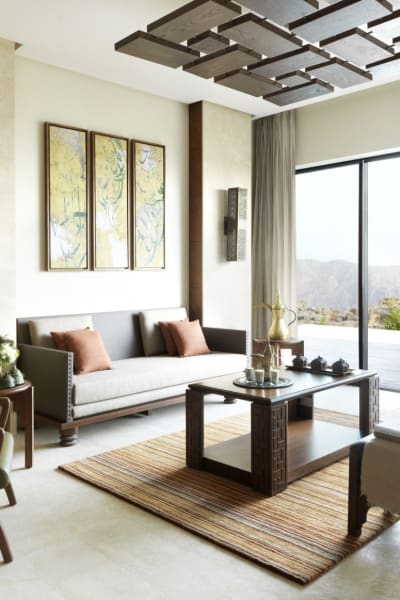 Modernes Wohnzimmer mit großen Schiebetüren, die zu einem Außenpool und Blick auf Grünflächen führen.