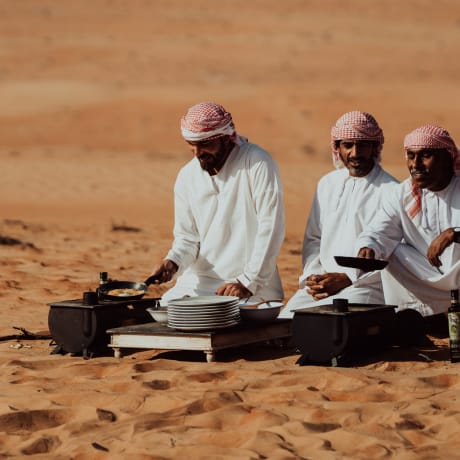 Omanis bereiten Essen in der Wueste zu