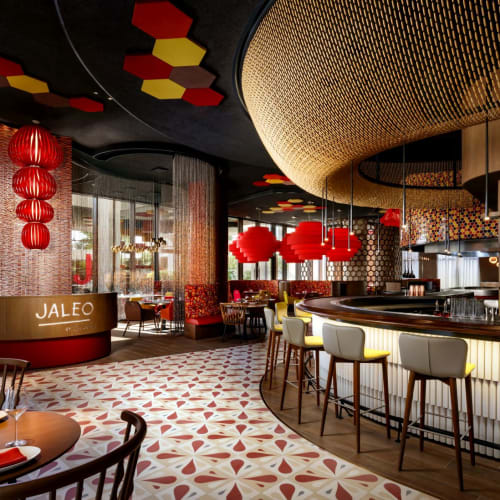 Elegantes Restaurant mit moderner Dekoration, roten Laternen und einer gekrümmten Bar mit Barhockern.