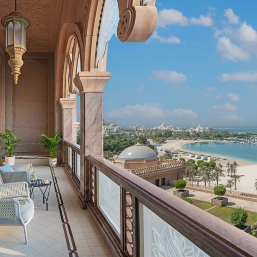 Luxury balcony overlooking a beautiful beach and lush gardens at Emirates Palace.