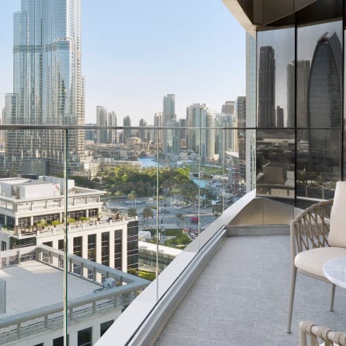 Ein Balkon mit Blick auf eine moderne Stadtskyline mit hohen Wolkenkratzern, gesehen von einem Hochhaus.