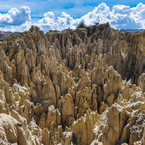 Eine zerklüftete Landschaft mit hohen, scharfen Felsformationen unter einem teilweise bewölkten Himmel in Valle de La Luna bei La Paz, Bolivien.