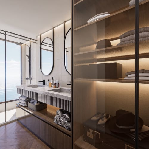 Modern bathroom with large glass shower overlooking the ocean, double sinks with items on the countertop, and shelves neatly stacked with towels and personal items.