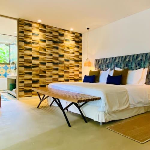 Spacious hotel room with a large bed, decorative wall, and a door leading to a balcony.