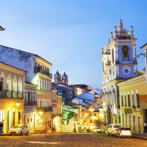 Bunte koloniale Gebäude und eine Kirche in Salvador da Bahia bei Dämmerung.