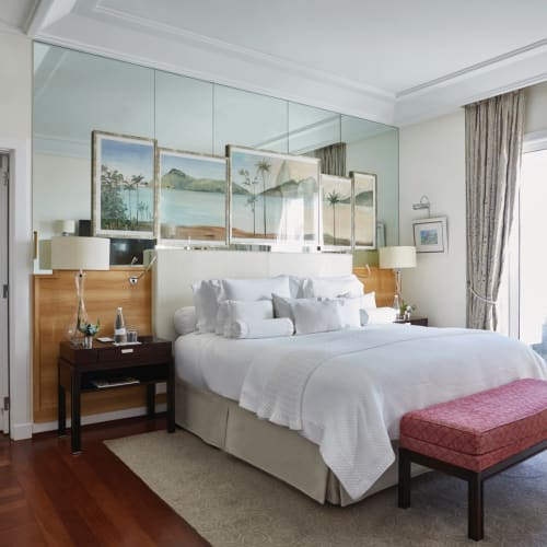 Luxuriöses Schlafzimmer in der Penthouse-Suite des Belmond Copacabana Palace mit großem Bett, Spiegelfronten und Balkonblick.