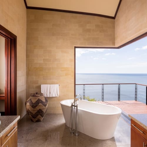 Luxurious bathroom with a standalone bathtub opening to an ocean view balcony at the Four Seasons Costa Rica Papagayo.