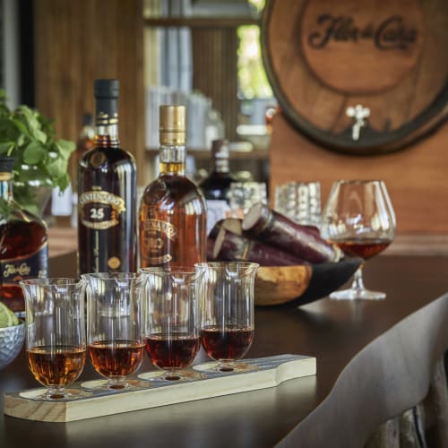 Eine Sammlung von Whiskyflaschen, Whiskeygläsern und eine Schale mit Limetten auf einer Bar-Theke.