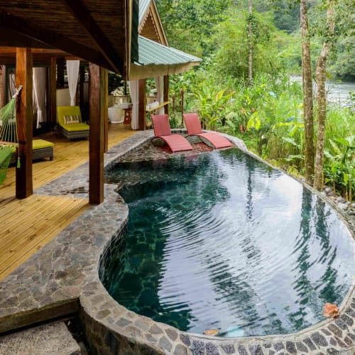 Luxus-Dschungelvilla mit kleinem Pool, umgeben von üppigem Grün und Blick auf einen Fluss in Costa Rica.