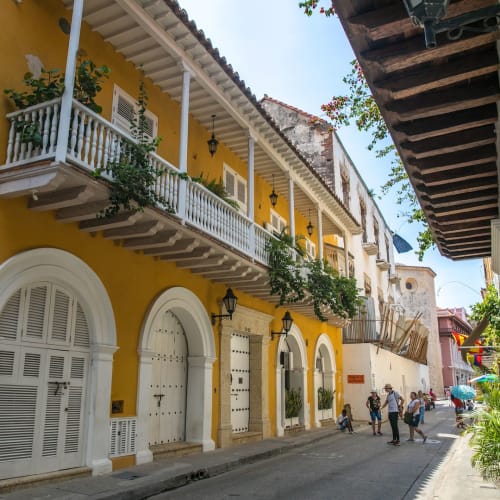 Buntes koloniales Gebäude mit Balkonen und Pflanzen in einer lebhaften Straße von Cartagena de Indias.