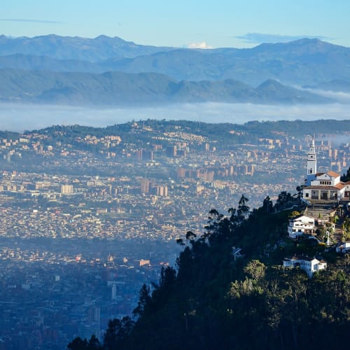 A view of Bogotá from Montserrat hill with city buildings and mountains in the background.