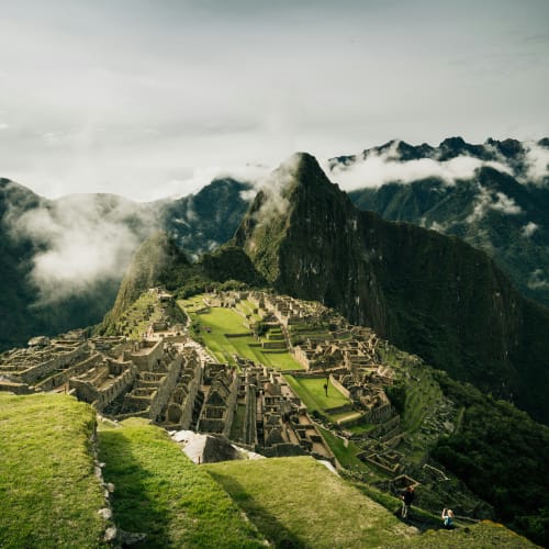 Machu Picchu, eine alte Inka-Festung hoch in den Anden in Peru, umgeben von nebeligen Wolken und grünen Terrassen.