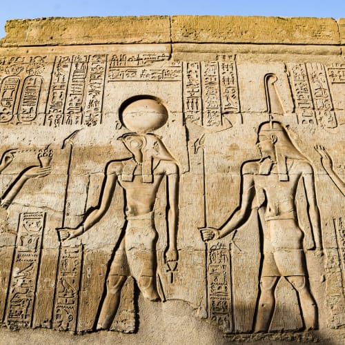 Altegyptische Wandreliefs mit Göttern und Hieroglyphen in einem Tempel.