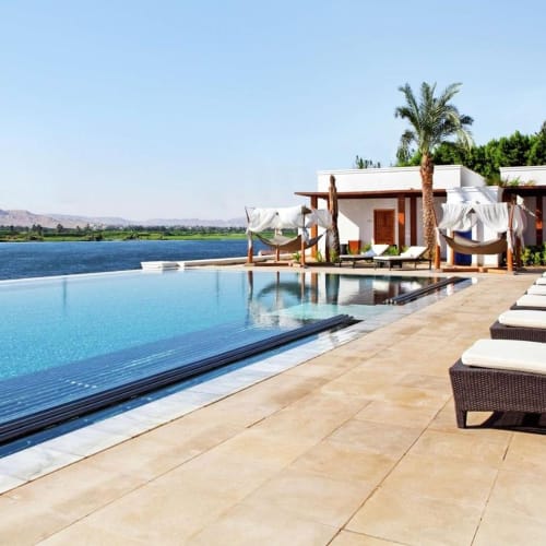 Luxuriöse Poolseite mit Sonnenliegen und Cabanas in einem Resort.