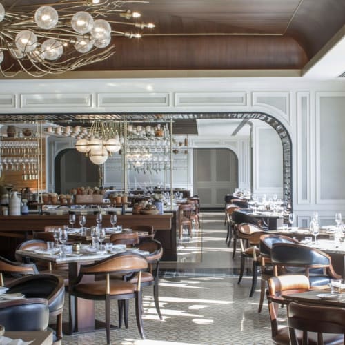 Eleganter Speiseraum in einem luxuriösen Hotelrestaurant mit großen Fenstern und moderner Dekoration.