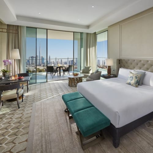 Luxuriöses Hotelzimmer mit großem Bett, Blick auf die Dubai-Skyline vom Balkon.