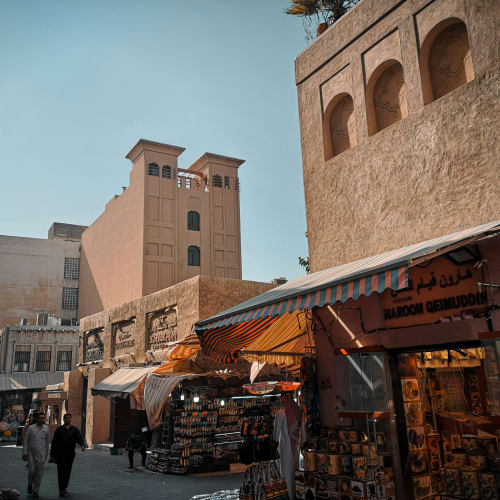 Straßenszene in Riad mit Marktständen und traditionellen Gebäuden unter einem klaren Himmel.
