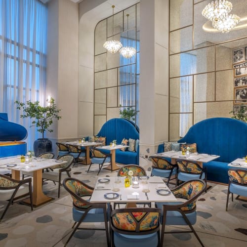 Eleganter Restaurantbereich mit blauen Samtstühlen und moderner Dekoration