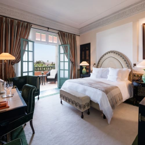 Luxuriöses Hotelzimmer mit Balkon, großem Bett und eleganter Einrichtung.