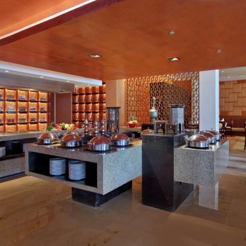 Ein Buffetbereich im Hilton Luxor Resort and Spa mit warmen Holzakzenten, Regalen mit Dekorationsgegenständen und Esstischen im Hintergrund.