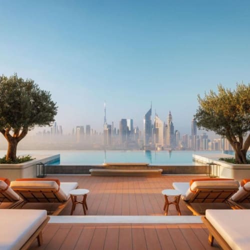 Elegante Terrasse mit komfortablen Liegestühlen und zwei großen Bäumen, davor ein Infinity Pool. Blick auf die Stadtskyline von Dubai im Hintergrund bei Sonnenlicht.