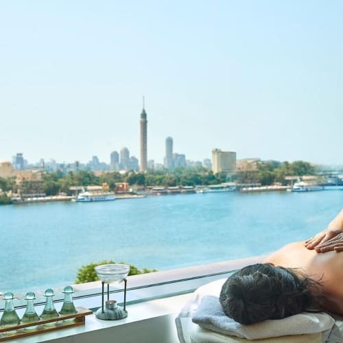 Eine Person, die in einem Spa mit Blick auf den Nil und die Skyline von Kairo massiert wird.