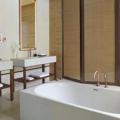 Modernes Badezimmer mit einer großen weißen Badewanne, Doppelwaschbecken und Holzakzenten in einer luxuriösen Umgebung.