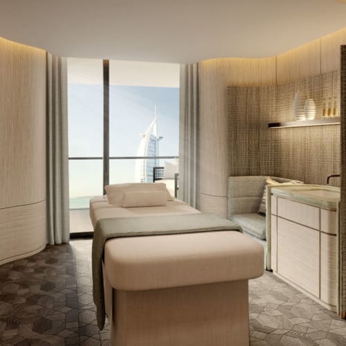 A luxurious spa room with a massage table, soft lighting, and large windows showing a city skyline.