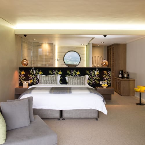 Ein modernes, gut ausgestattetes Hotelzimmer mit Doppelbett, Sofa und dekorativen Elementen.