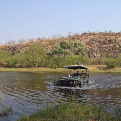 Ein Safari-Fahrzeug mit Dach Überquerung eines Flusses in der Savute-Region in Botswana.