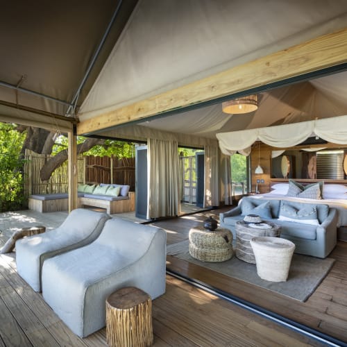 Luxurious safari suite with outdoor seating area, overlooking lush greenery in Mana Pools, Zimbabwe.