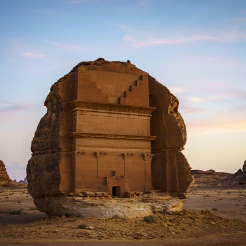 Alte in einen Sandsteinfelsen gehauene Grabstätten in AlUla, Saudi-Arabien, bei Sonnenuntergang.