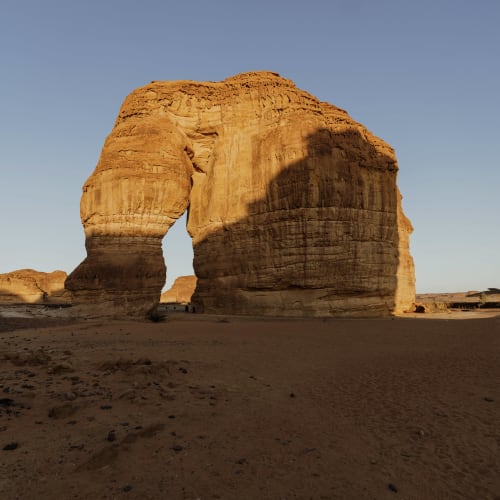 Eine große natürliche Felsformation, die in Al-Ula an einen Elefanten erinnert, unter einem klaren Himmel.