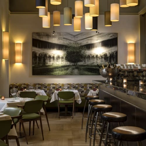 Elegant restaurant interior in Florence with modern lighting, artwork, and seating arrangements.