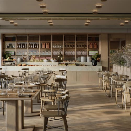 Elegant, well-lit restaurant with wooden tables and chairs, set for dining with glasses and utensils, and a buffet area in the background.