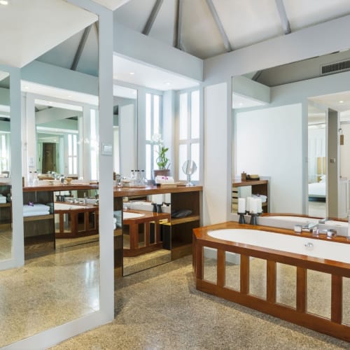 Luxurious hotel suite interior featuring a bathtub near a window and modern decor.
