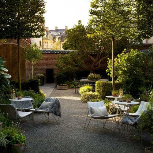 A cozy outdoor garden with tables, chairs, and lush greenery in Stockholm.