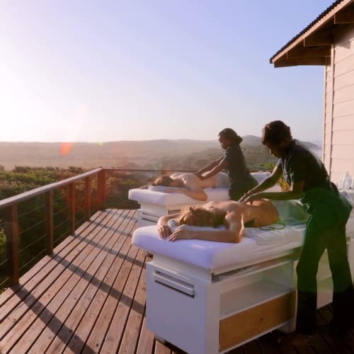 Spa-Behandlung im Freien auf einer Holzterrasse mit Blick auf die Natur im White Pearl Resort, Mosambik.