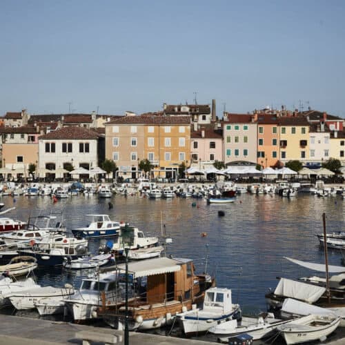Colorful buildings along a marina filled with boats in a coastal town.